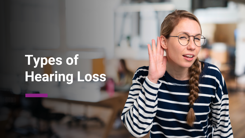 A young woman with glasses and a striped shirt holds her hand to her ear, appearing to listen intently. The background is a blurred office setting. The image text reads "Types of Hearing Loss."