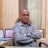 Dr. Ajay Agrawal sitting at his desk.